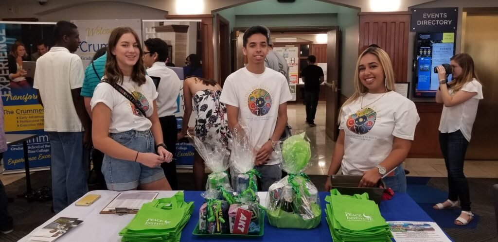 Young adults staff a community engagement booth at an event.